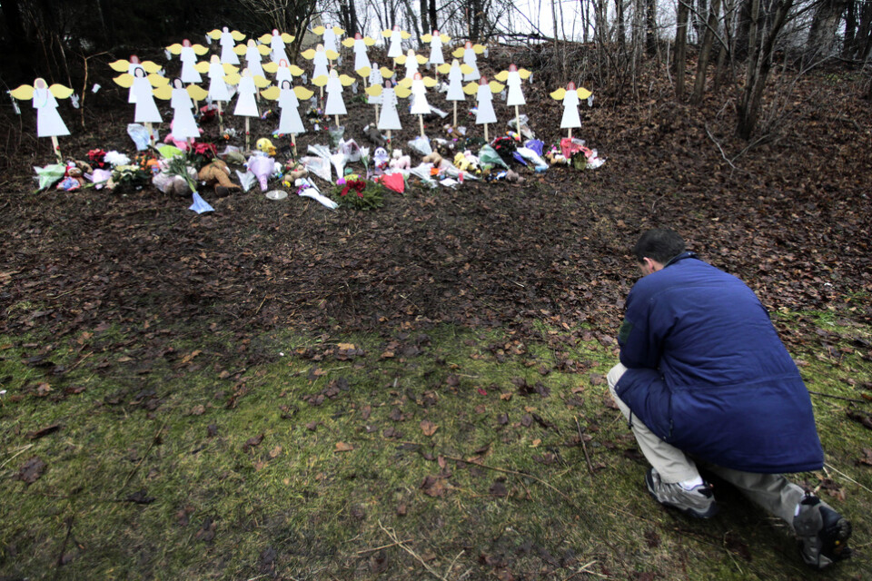 En man hedrar offren vid den minnesplats som utformades efter Sandy Hook-massakern år 2012 då 20 barn och sex lärare mördades av en ensam gärningsman Arkivbild
