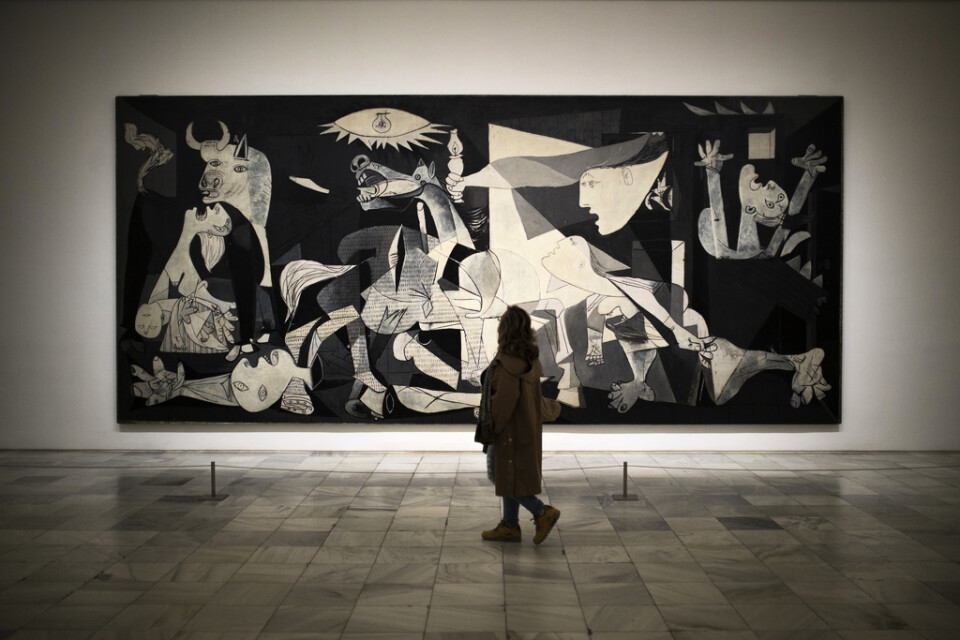 En kvinna tittar på Pablo Picassos originalmålning "Guernica". Arkivbild.