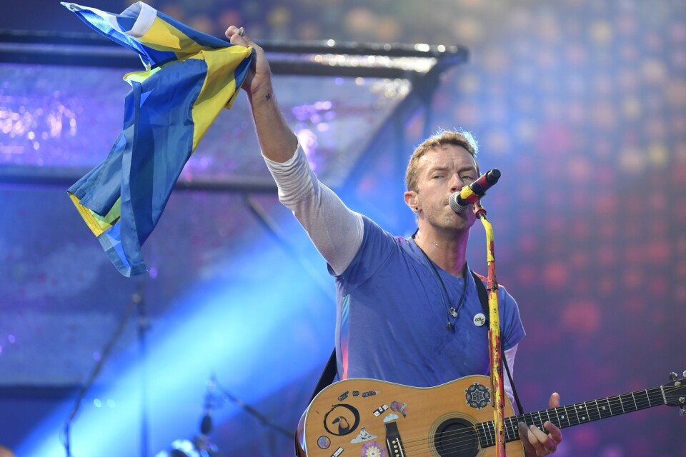 Chris Martin lyfter en svensk flagga under en spelning på Ullevi i Göteborg 2017. Arkivbild.