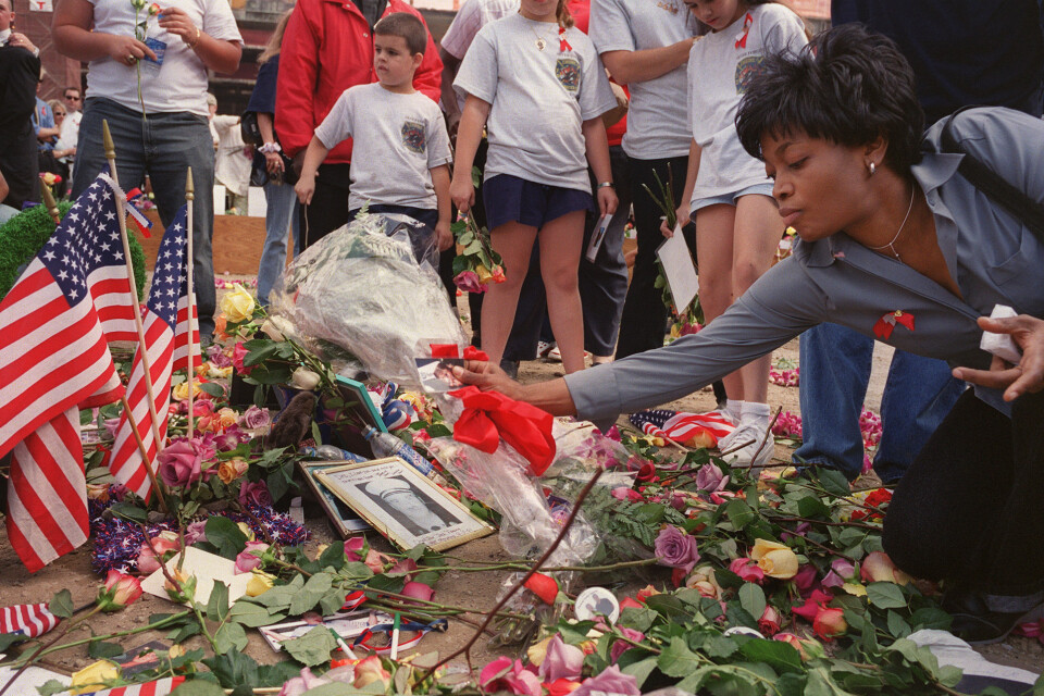 En kvinna i New York lägger blommor vid en minnesstund på den första årsdagen efter terrorattacken mot World Trade Center – för 20 år sedan, 2002.
