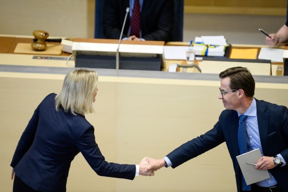 Finansminister Magdalena Andersson (S) skakar hand med Moderaternas ekonomisk-politiske talesperson Ulf Kristersson under budgetdebatten i riksdagen.