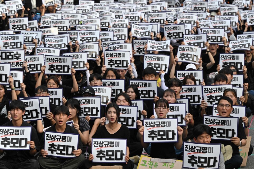 Demonstranter i Seoul. På plakaten står det "Att avslöja sanningen är ett sätt att visa respekt".