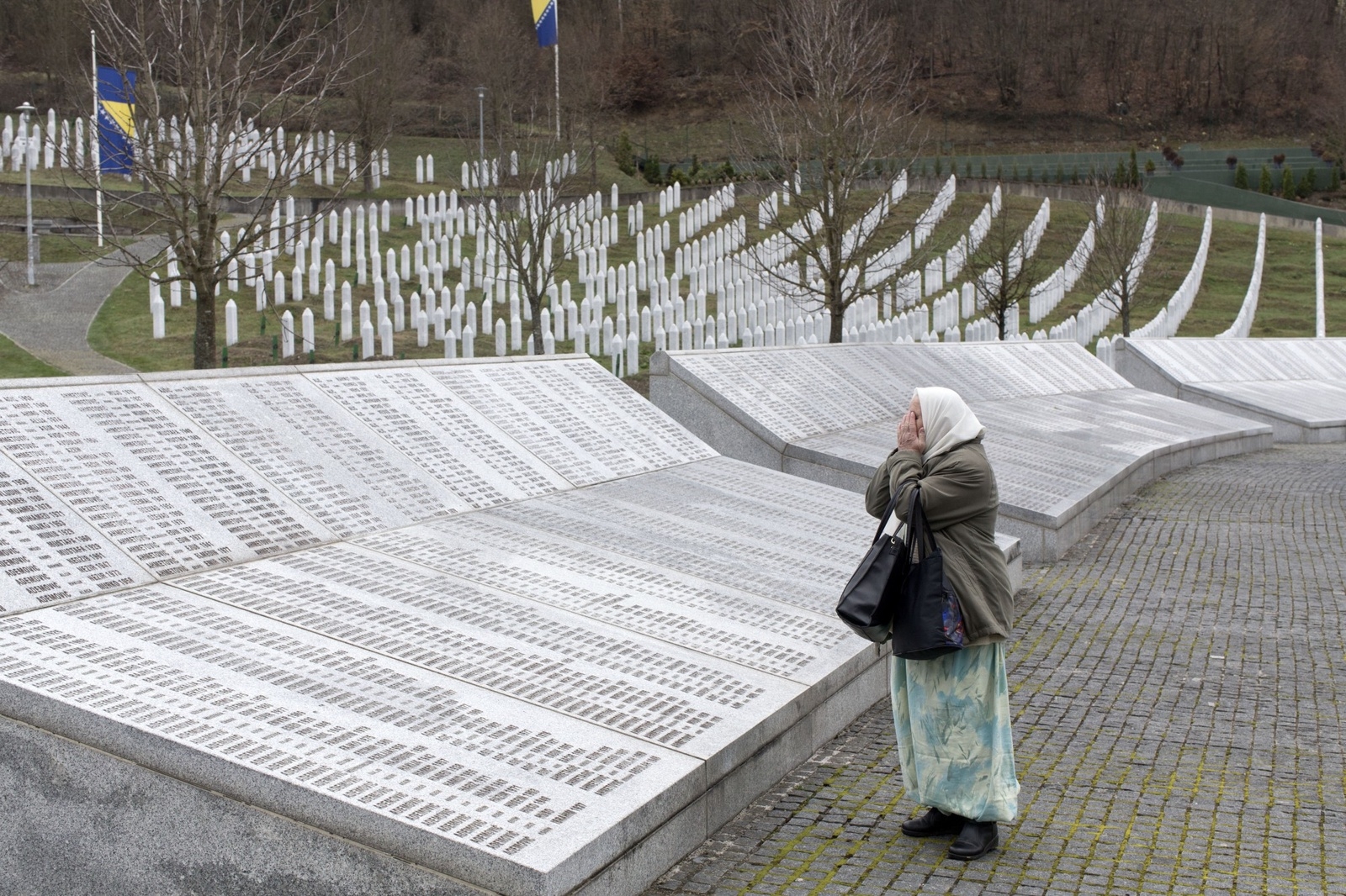En kvinna ber vid minnesplatsen för offren för folkmordet i Srebrenica i Potocari Bosnien Herzegovina. Foto: Marko Drobnjakovic/AP/TT