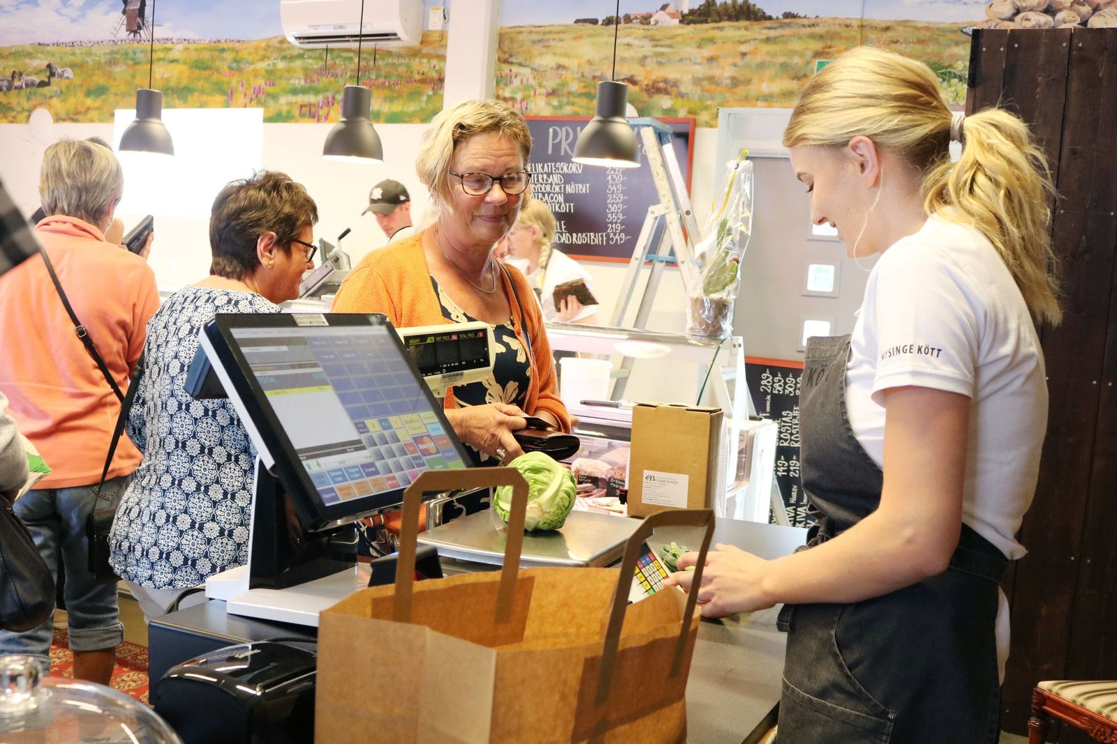 Helén Lund blir den första kunden som handlar av Madelene Åhlund efter att butiken är invigd.