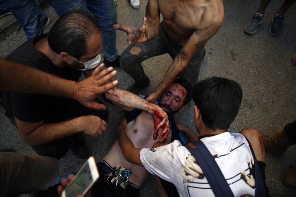 En skadad demonstrant får hjälp i Beirut.