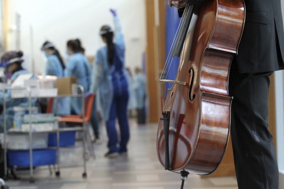 En musikstudent spelar cello under covidvaccinationerna på ett medicinskt universitet i Edinburg i Texas.