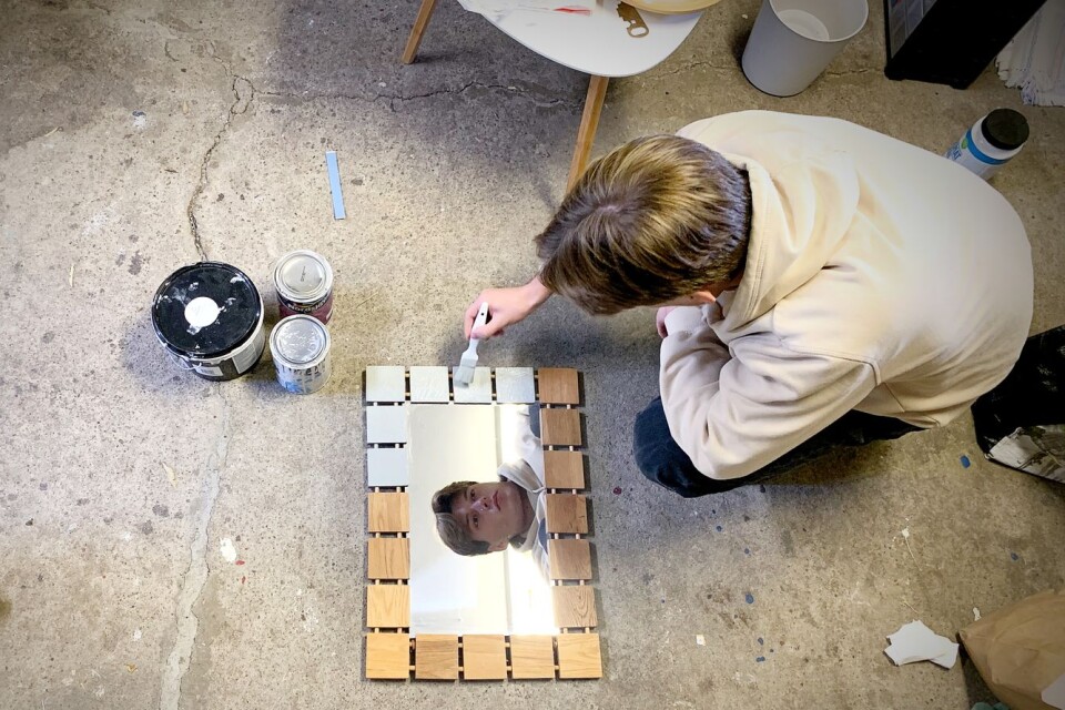 Emil Hansen mends a mirror. The firm finds objects to renovate in different places, including jumble sales.