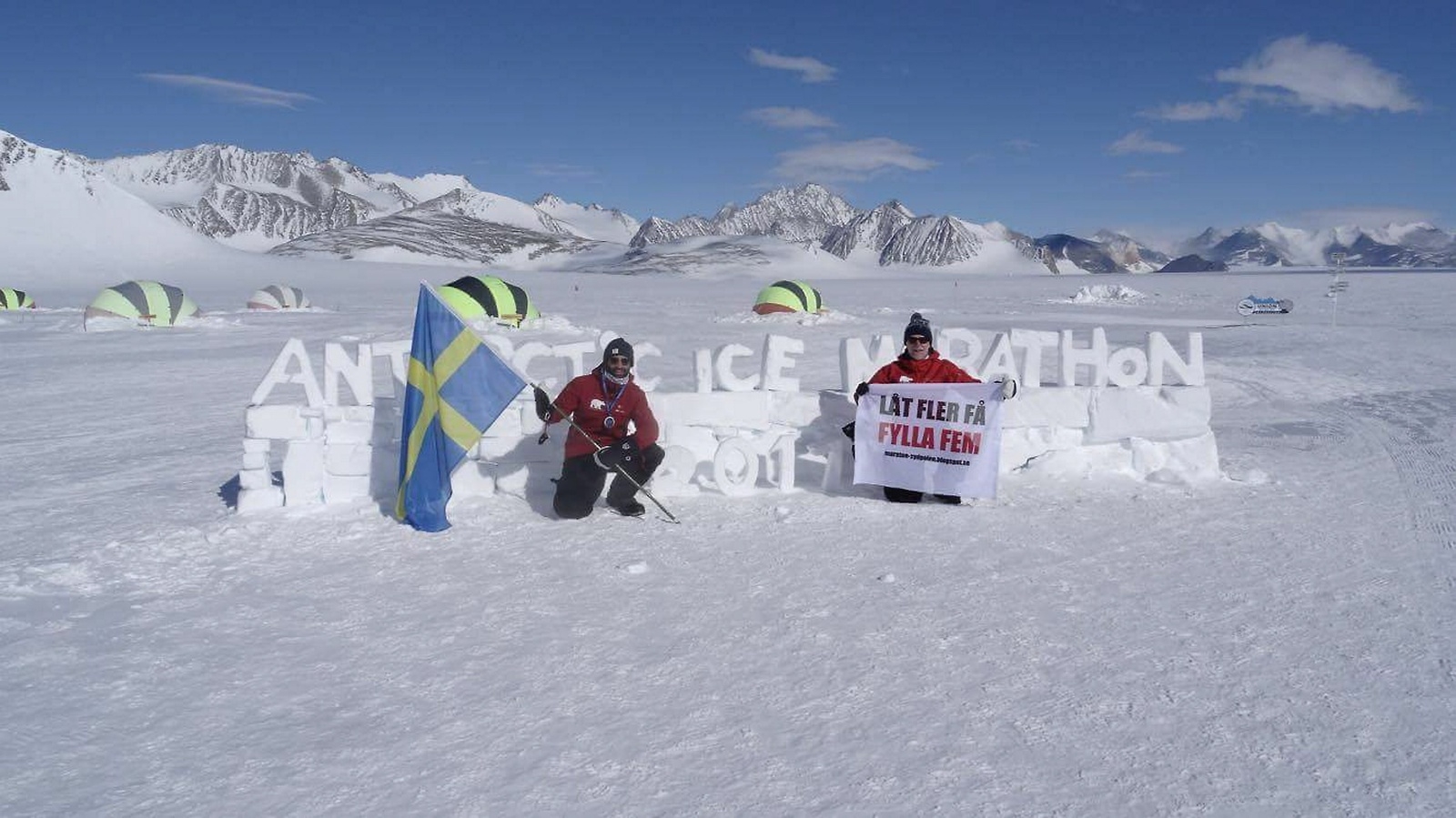 Efter målgången på Sydpolen var Håkan Jonsson (till höger) och hans son Andreas Jonsson trötta men nöjda, då de kunde flagga både med den svenska fanan och med sitt budskap: Fight Child Mortality (bekämpa barnadödligheten).Foto: privat