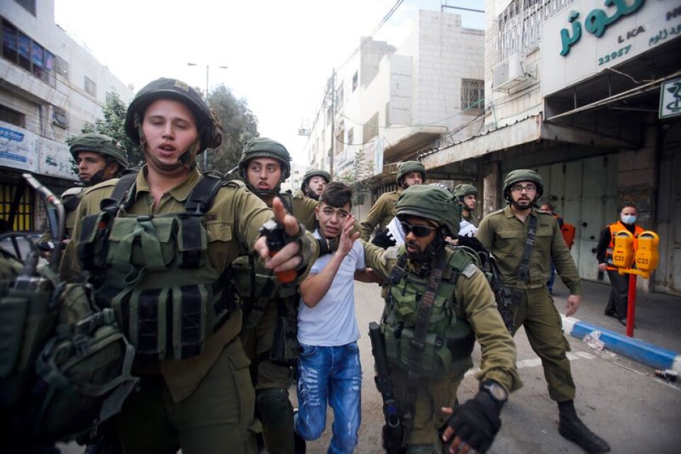 En palestinsk pojke grips av israelisk militär under oroligheterna efter beskedet att USA erkänner Jerusalem som Israels huvudstad.