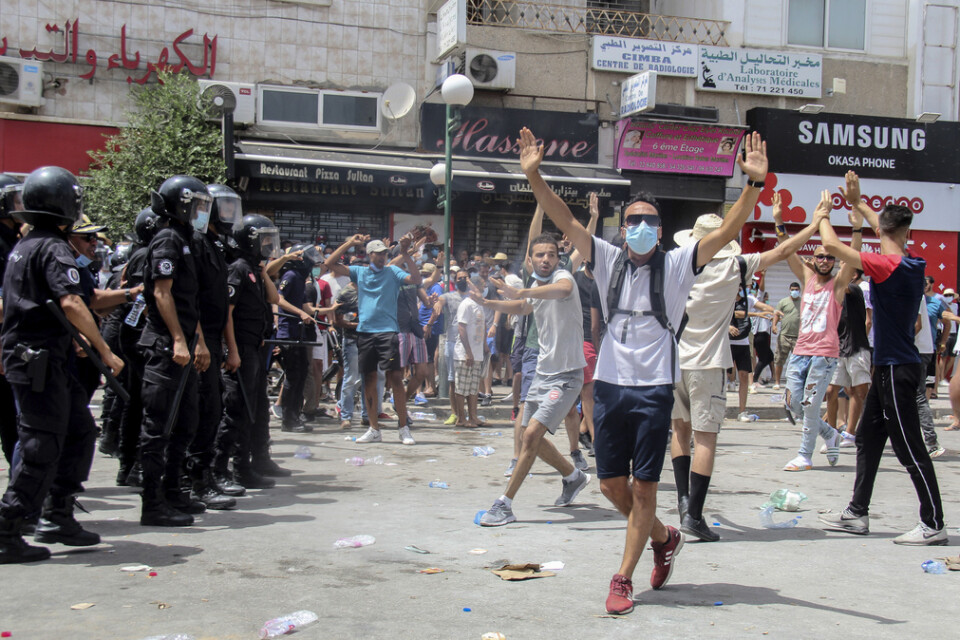 Demonstranter och polis i Tunis på söndagen.