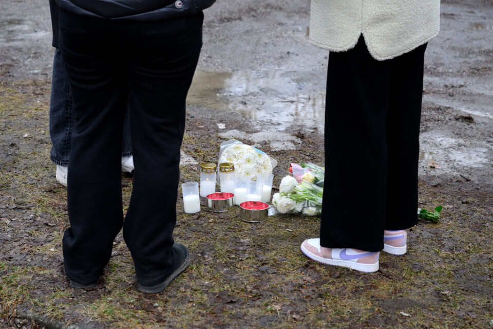 Blommor och ljus på parkeringen utanför gymnasieskolan i Eskilstuna där en man i 20-årsåldern sköts till döds för en dryg vecka sedan.