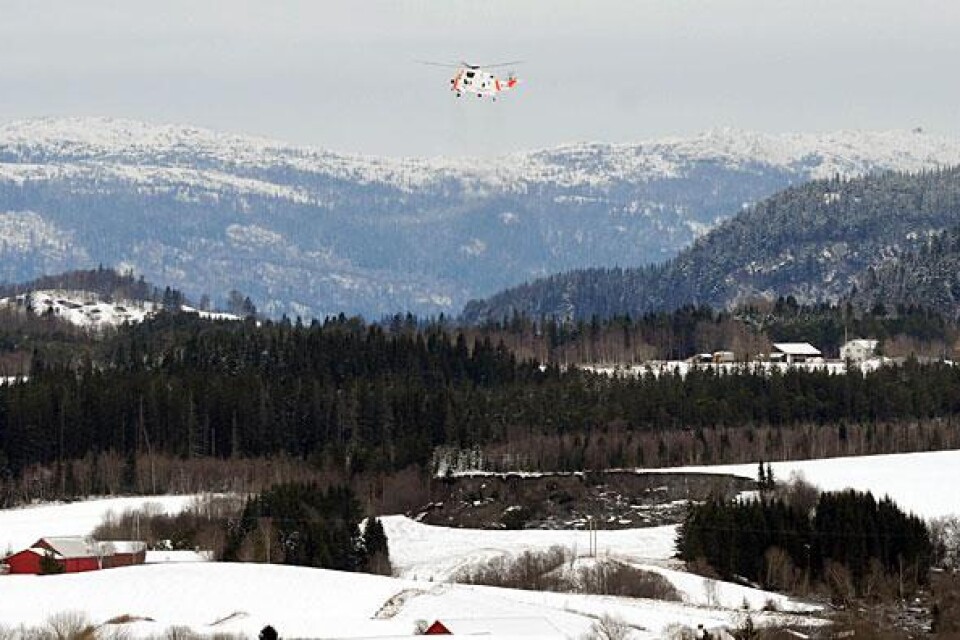 En räddningshelkopter söker efter saknade personer efter ett jordsked som inträffade i Esp vid Spongda utanför Trondheim i Norge på nyårsdagens morgon.