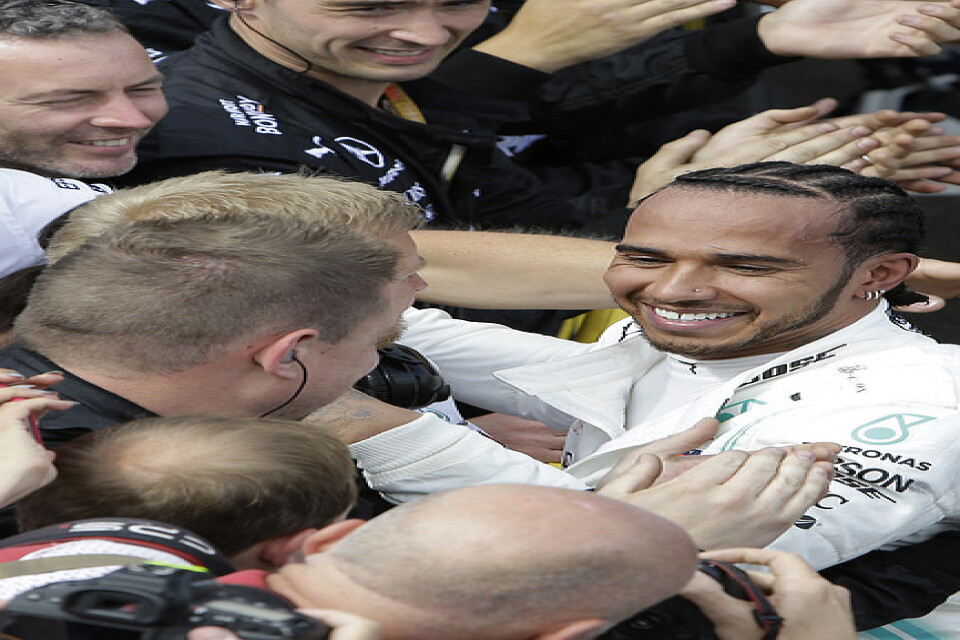 Lewis Hamilton jublar med sitt stall efter segern.
