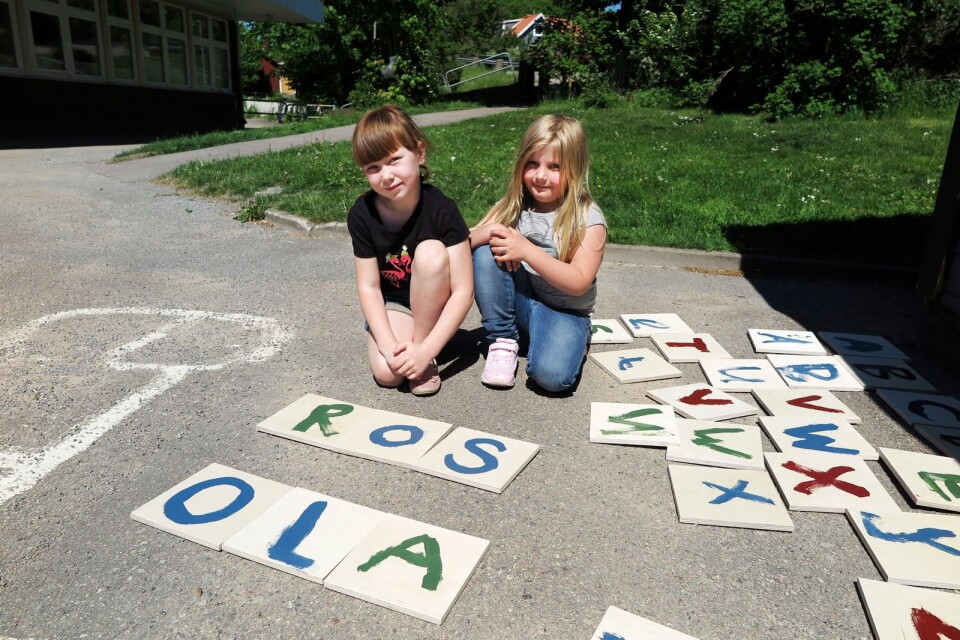 Lovisa Nilsson och Naemi Sjögren målar bokstäver på träbitar de sedan kan spela Alfapet med.