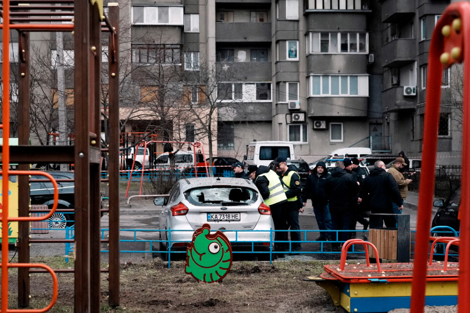 Poliser tar en titt på en bil som tog skada i en raketattack mot Kiev under natten till torsdag.