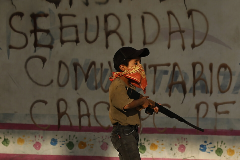 Ett barn övar med sitt leksaksgevär. Byn Ayahualtempa i delstaten Guerrero – en av de mest våldsdrabbade delstaterna i hela Mexiko – hotas av framför allt två lokala knarkgäng: Los ardillos och Los rojos.