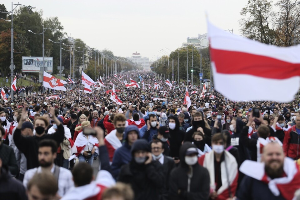 Demonstranter i Minsk viftar med en alternativ belarusisk flagga som ska symbolisera ett demokratiskt Belarus. Hundratusentals människor demonstrerade i Belarus 2020, men regimen slog ned missnöjet med rysk hjälp. Arkivbild.