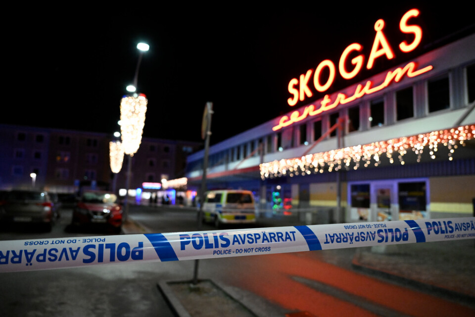 Polisavspärrningar vid brottsplatsen i Skogås centrum, där den 15-årige pojken sköts ihjäl i slutet av januari i år. Arkivbild.