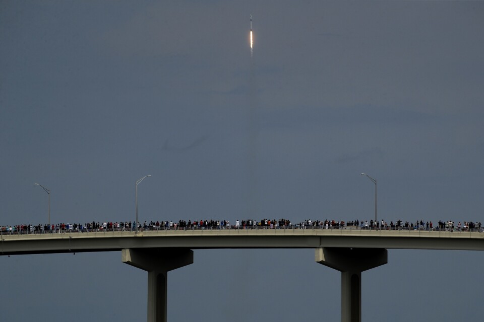 Raketuppskjutningar är ett folknöje i Florida, även i covidtider. Här beundrar samlade åskådare den stigande Falcon 9-raketen från en bro i Titusville.