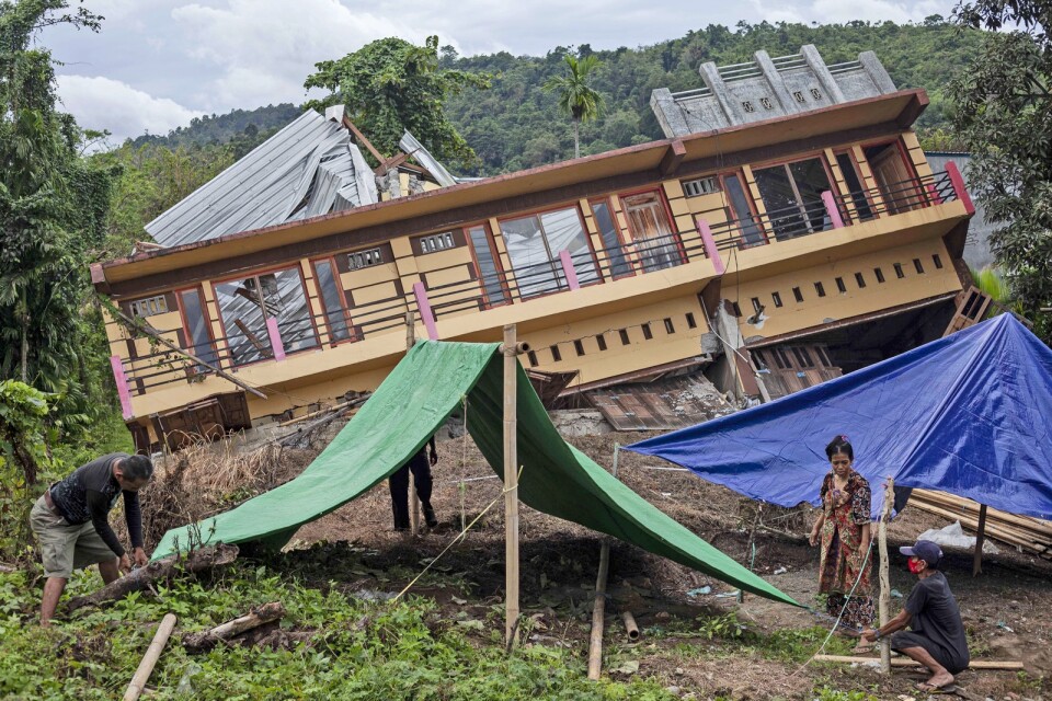 Invånare i Mamuju som förlorat sina hem i skalvet sätter upp provisoriska tält.
