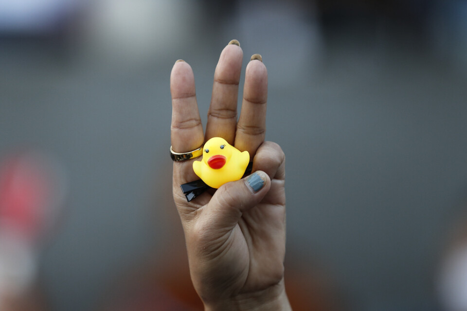 En demonstrants hand vid en regimkritisk protest i Bangkok. De tre höjda fingrarna och den gula ankan är båda symboler för proteströrelsen. Arkivbild.