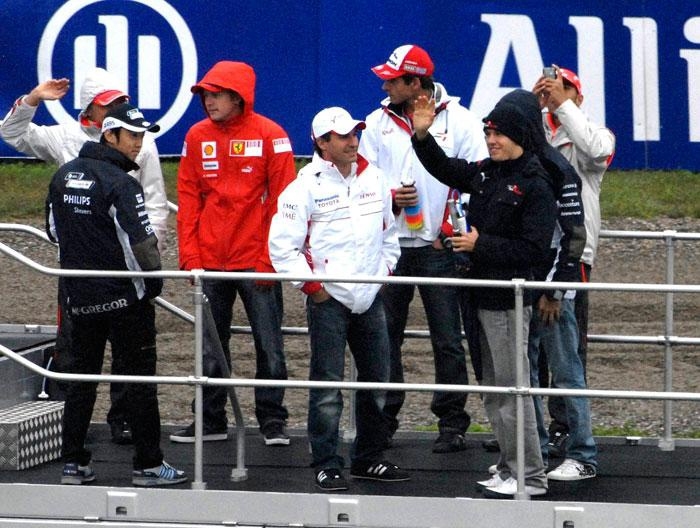 Stjärnparad. Heikki Kovalainen, Kazuki Nakajima, Kimi Räikkönen, Timo Glock, Adrian Sutil, Sebastian Vettel, Nico Rosberg och Lewis Hamilton som fotograferar.