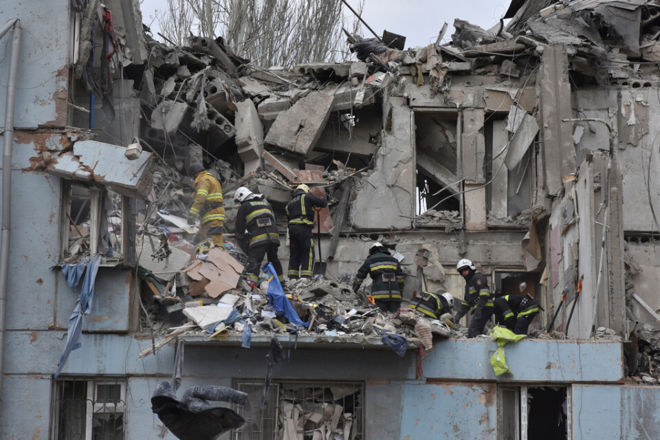 Ukrainsk räddningstjänst inspekterar ett bombat hus i Zaporizjzja på fredagen.