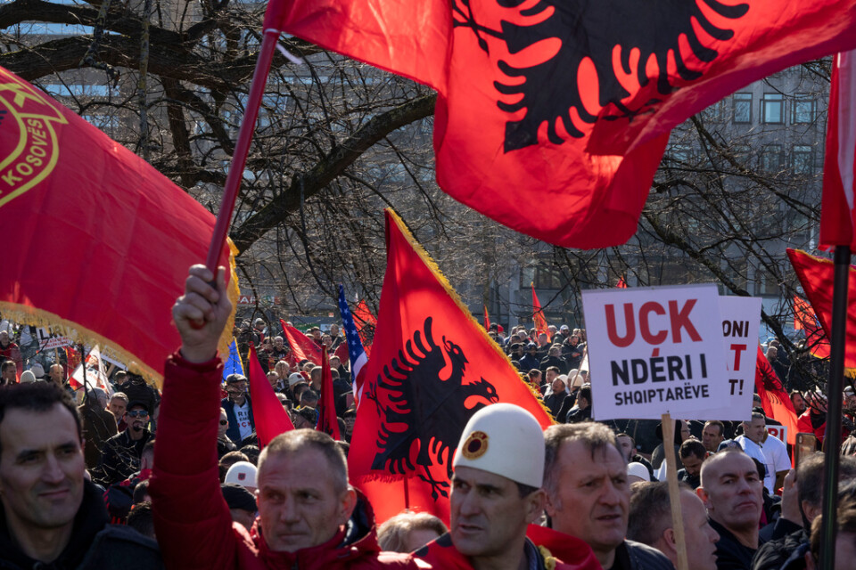 Anhängare till Hashim Thaçi och tre medåtalade protesterar i Haag i samband med rättegångens start.