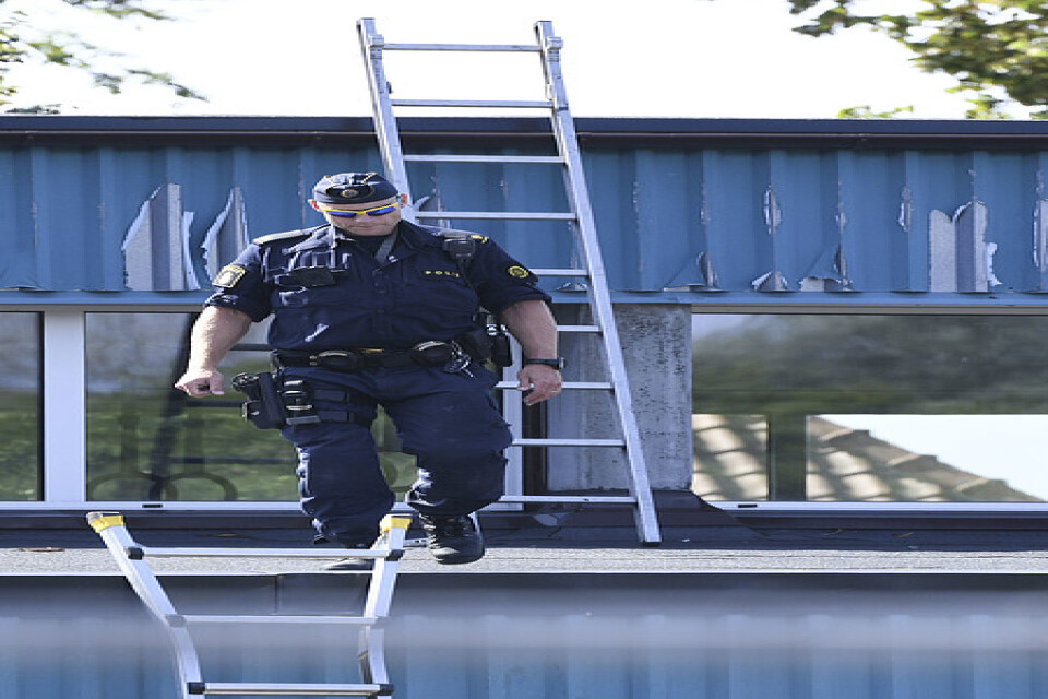 Poliser undersöker ett tak på den plats i Kristianstad där flera personer skadats efter ett våldsbrott under måndagen. Arkivbild.