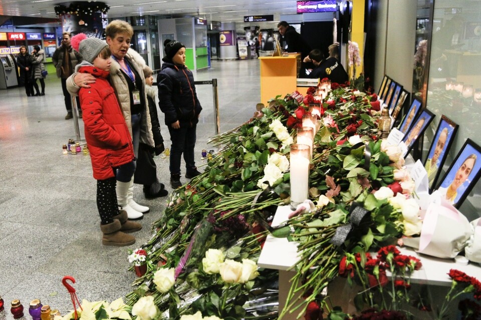 Blommor och ljus på den internationella flygplatsen i Kiev intill bilder på de ukrainska besättningsmedlemmar som dödades vid nedskjutningen i Iran.