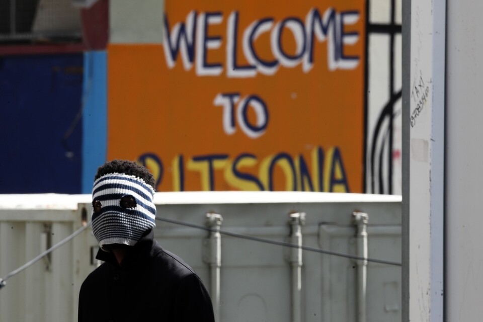 En ung man i lägret Ritsona har täckt sitt ansikte för att skydda sig mot coronaviruset.