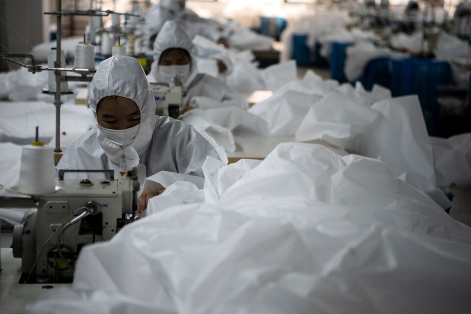 Anställda på Ugly Ducks fabrik i Wenzhou i Zhejiangprovinsen syr skyddsdräkter som ska användas i det pågående utbrottet av det nya coronaviruset. Bild från 28 februari 2020.