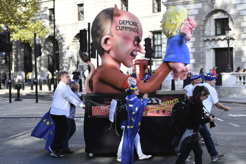 En figur föreställande rådgivaren Dominic Cummings som håller i en kasperdocka som föreställer premiärminister Boris Johnson. Bilden är tagen under en protest anordnad av brexitmotståndare. Arkivbild.