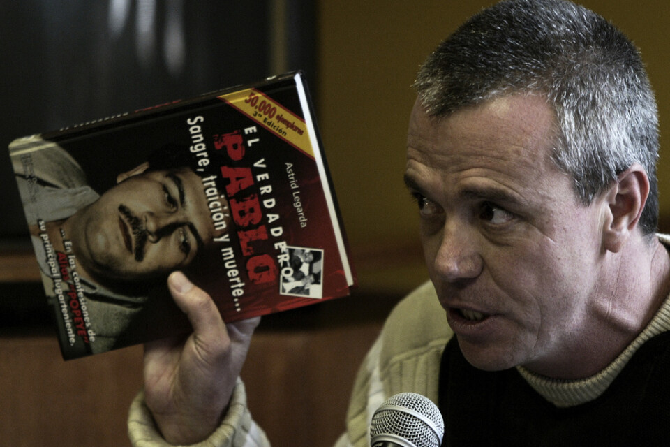 Yrkesmördaren Jhon Jairo Velasquez, här med en bok om sin forne chef Pablo Escobar, har gått bort i cancer. Arkivbild.