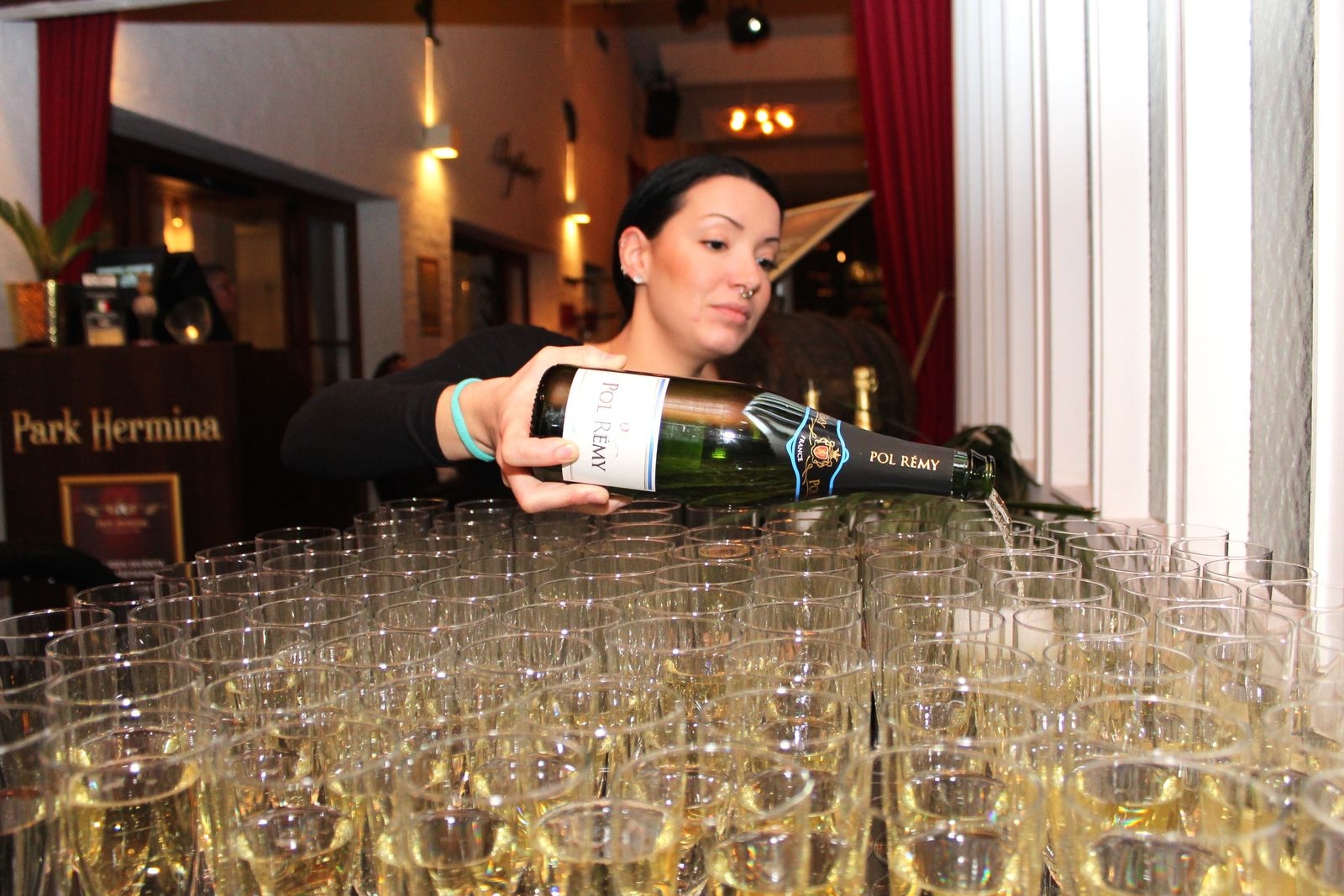 Stina Zetterman fyller på champagnen till alla gäster.