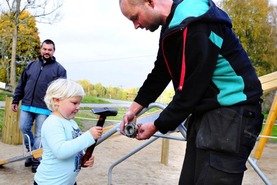 Elsa Uleskog, 3 år, bankar fast ett kugghjul. Tony Palmér är hjälpreda.
