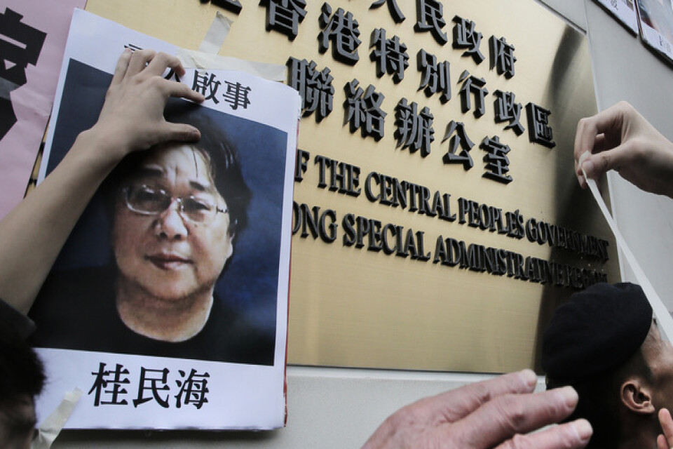 En bild från Hongkong, januari 2016. Demonstranter sätter upp bilder på försvunna bokhandlare, däribland Gui Minhai, vid en regeringsbyggnad i staden.