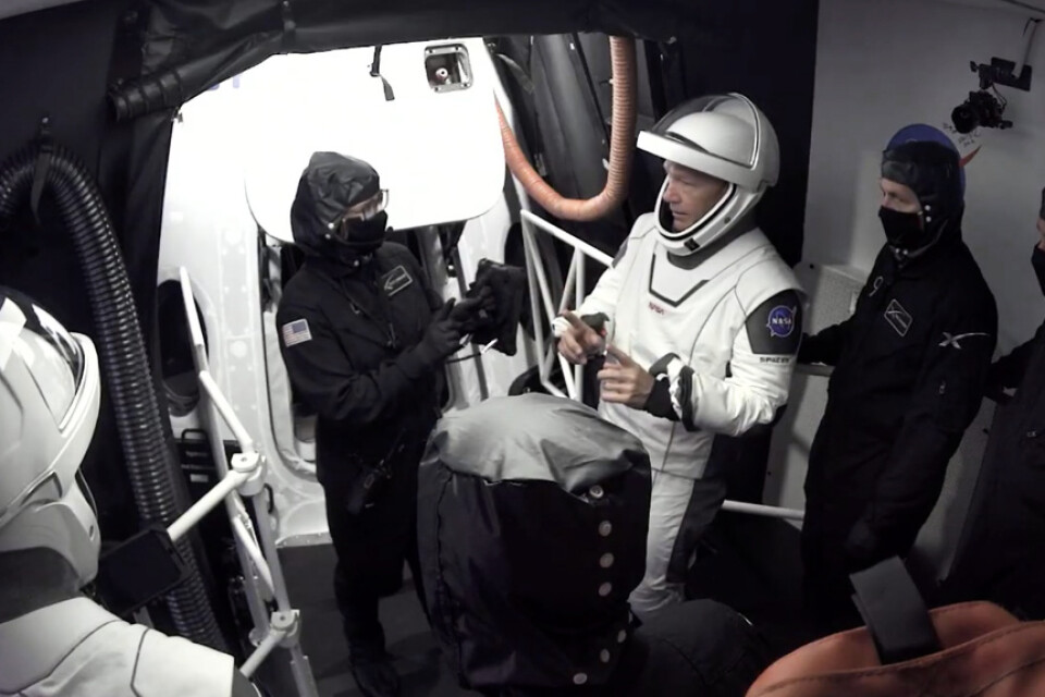 Astronauterna Doug Hurley och Bob Behnken lämnar kapseln Crew Dragon efter onsdagens avbrutna försök att skjuta upp raketen.