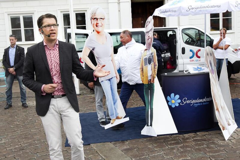 Sverigedemokraternas partiledare Jimmie Åkesson och hans pappersdockor gästade Ystad på måndagen. Hunden är med för att vakta barnkammaren från feminister och Gudrun Schyman.