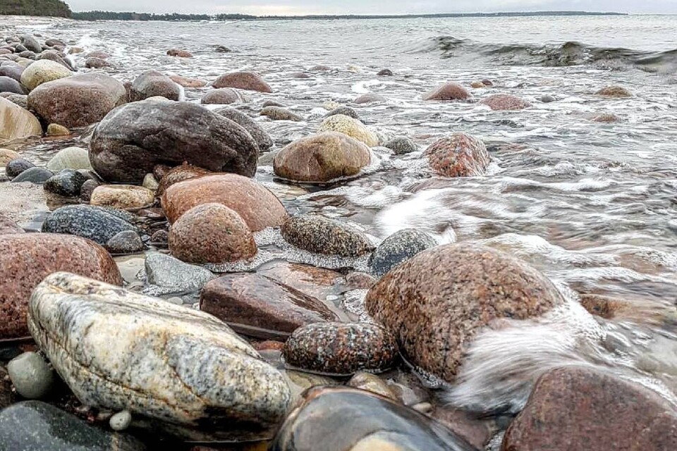 Havet slår mot stranden i våg efter våg. De runda stenarna blir för varje våg en aningens aning mer unika.