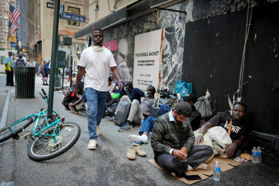 Migranter köar utanför The Roosevelt Hotel i New York, som fungerar som tillfälligt boende för hemlösa.