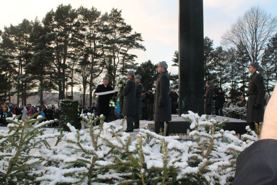 Finlands president Sauli Niinistö lade den första kransen vid hjältegravarna på Sandudds begravningsplats i Helsingfors. Sedan läste han texten på det blåvita bandet. Foto: Lars Näslund.