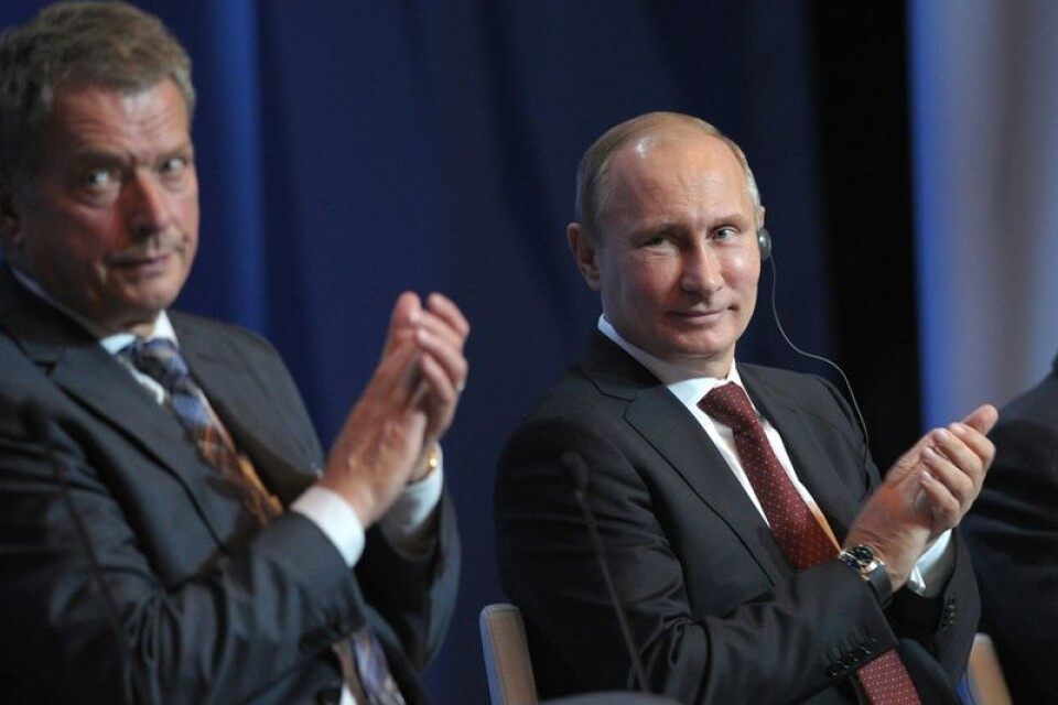 Rysslands president Vladimir Putin och Finlands president Sauli Niinistö applåderar tillsammans.