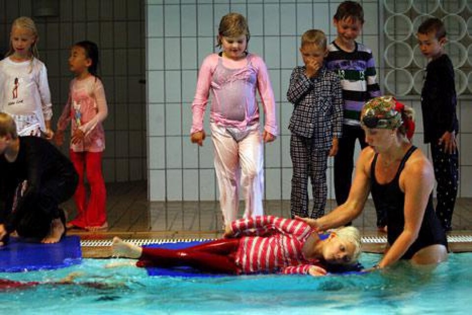 Karolina Jonasson hjälper Heidi Uhde Zinkernagel att rulla ner i vattnet.