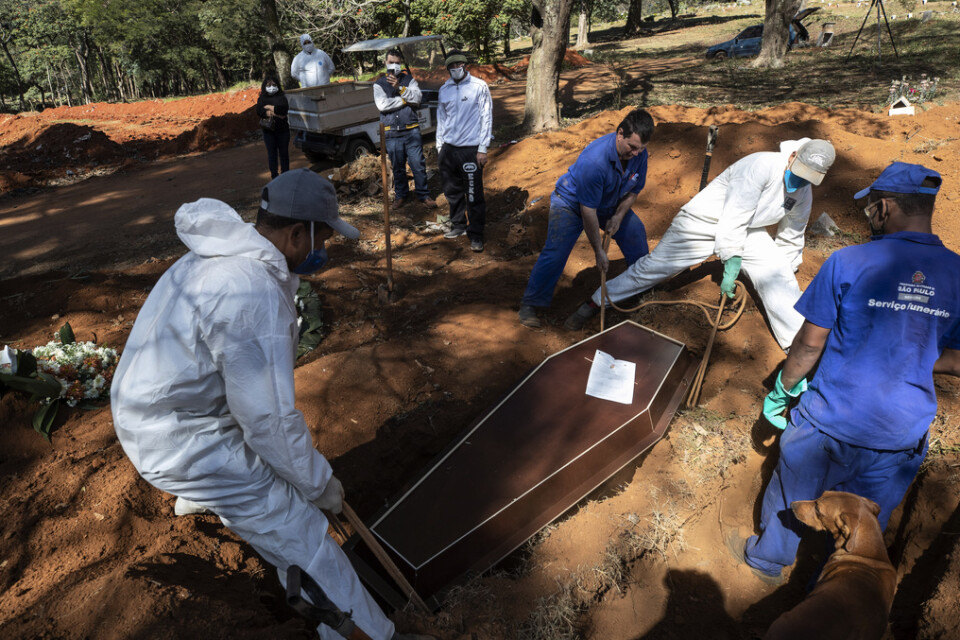 Kyrkogårdsarbetare begraver människor som avlidit till följd av covid-19 i São Paulo i Brasilien.