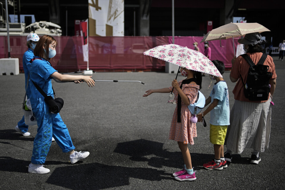 Gratis paraplyer ska skydda Kumagayas skolbarn. På bilden erbjuder en volontär svalka i Tokyo i fjol.