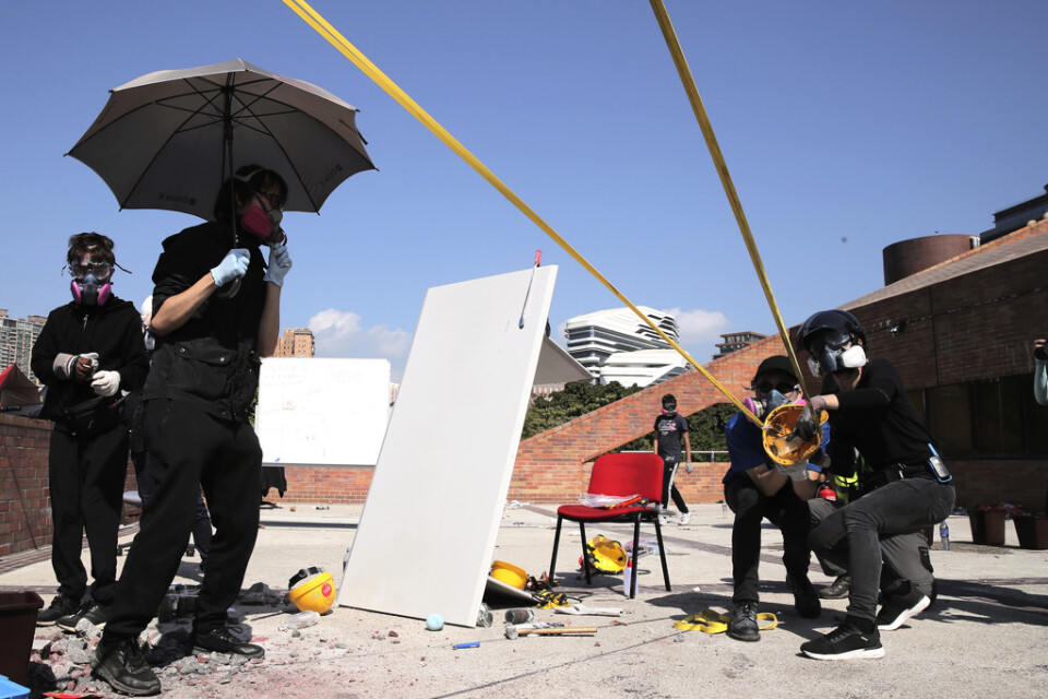 Demonstranter använder sig av jättelika slangbellor under sammandrabbningar med polisen.