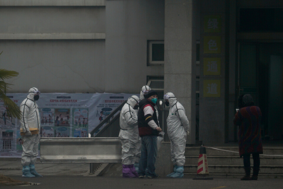 Personal i skyddsdräkt i Wuhan.