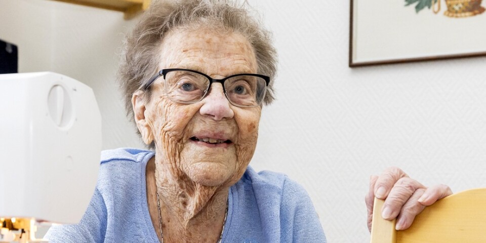 ”Jag älskar min symaskin, den står nästan alltid framme på köksbordet”, säger Margit Blomquist som nu fyller 100 år. Den broderade tavlan på väggen har hon gjort själv.