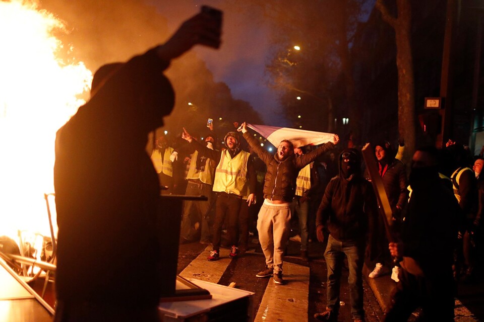 En selfie med grabbarna och en brinnande bil i bakgrunden. De ”gula västarna” vet att dokumentera sina protester till eftervärlden.